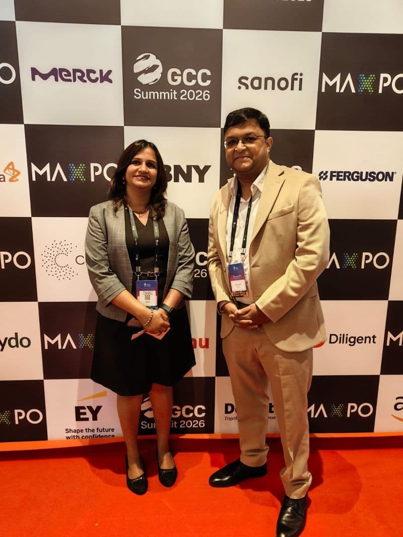 Two TalentiFi-X delegates wearing event lanyards beside the GCC Summit 2026 sponsor backdrop.