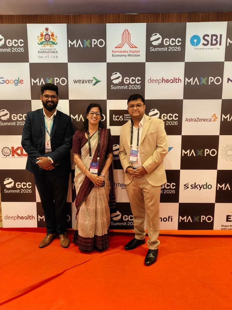 Three TalentiFi-X delegates at the GCC Summit 2026 backdrop featuring the Government of Karnataka and Karnataka Digital Economy Mission logos.